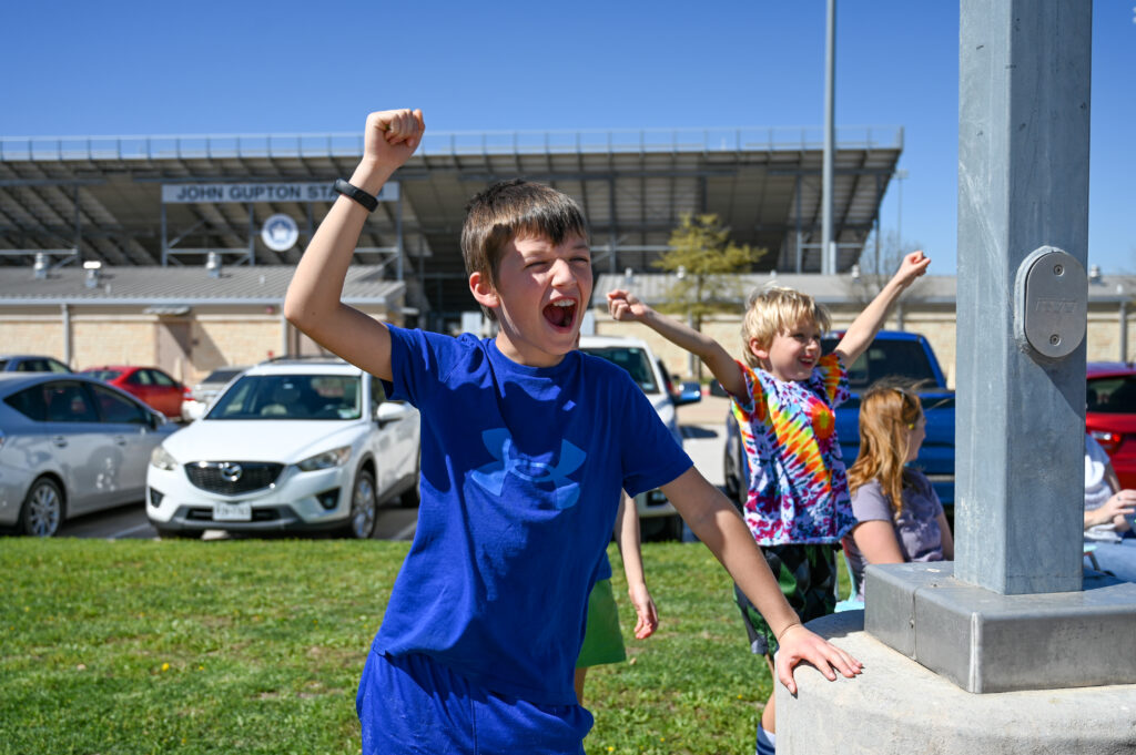 children cheering on the bus drivers at the bus roadeo