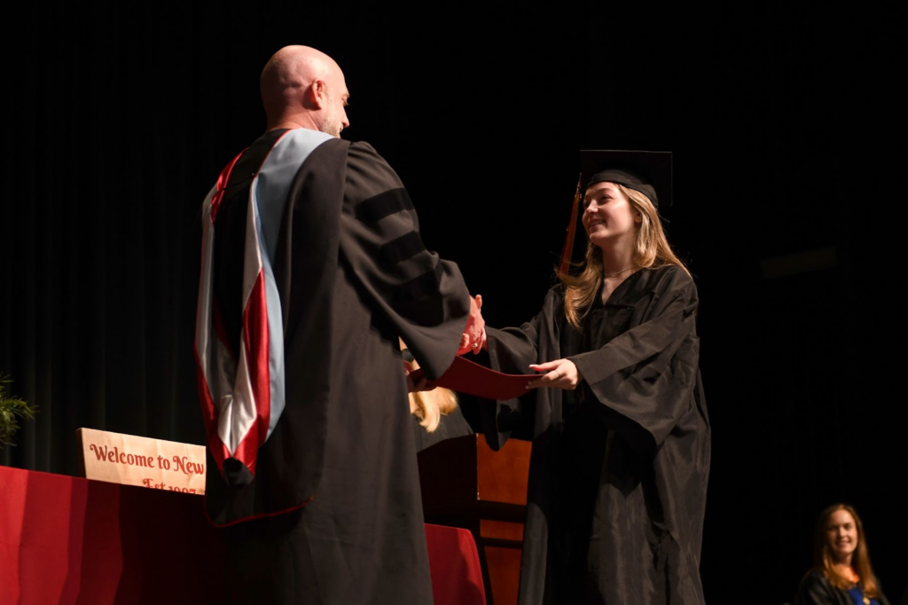 LISD High School Graduate receiving certificate from Principal on stage.