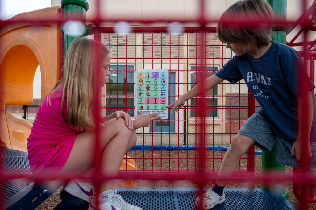 LISD students using a communication board in the playground