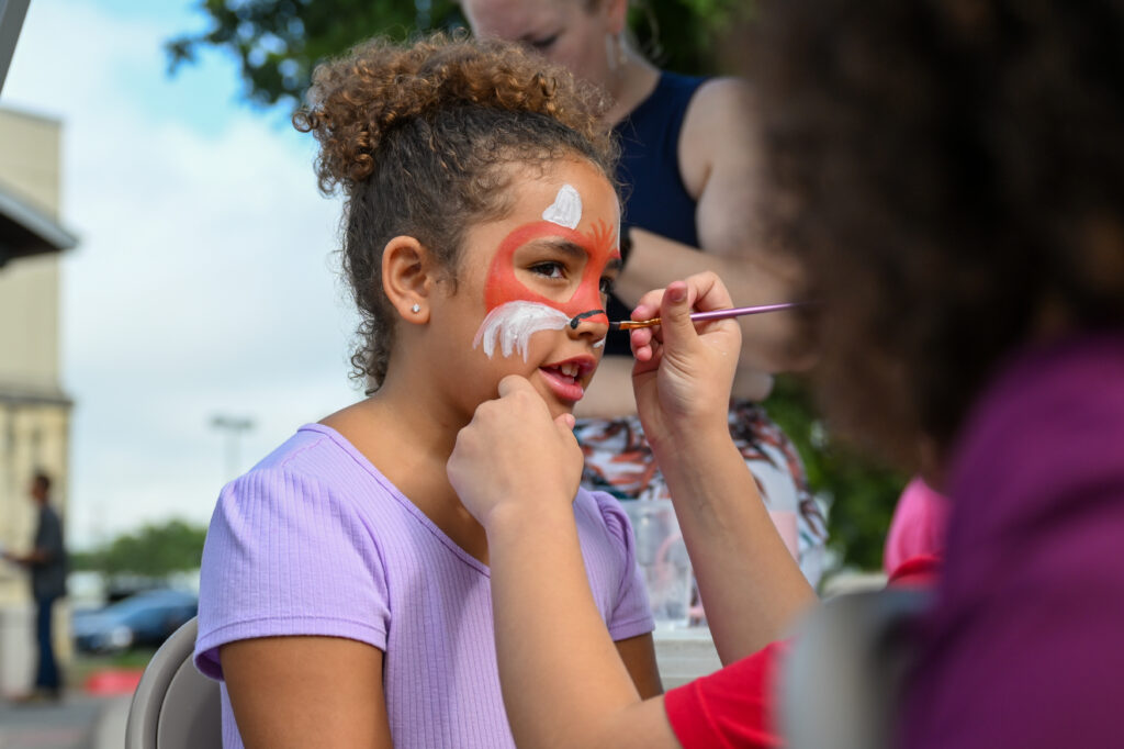 A child having their face painted at the Backpack Attack Event, July 2024