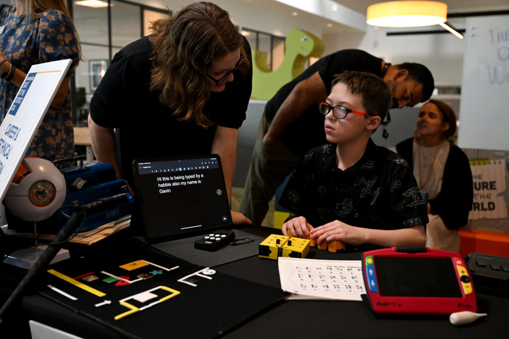 Student working with visual impairment tools at exhibition