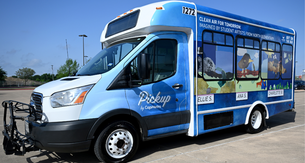 A CapMetro bus with a vehicle wrap featuring artwork from North ES students