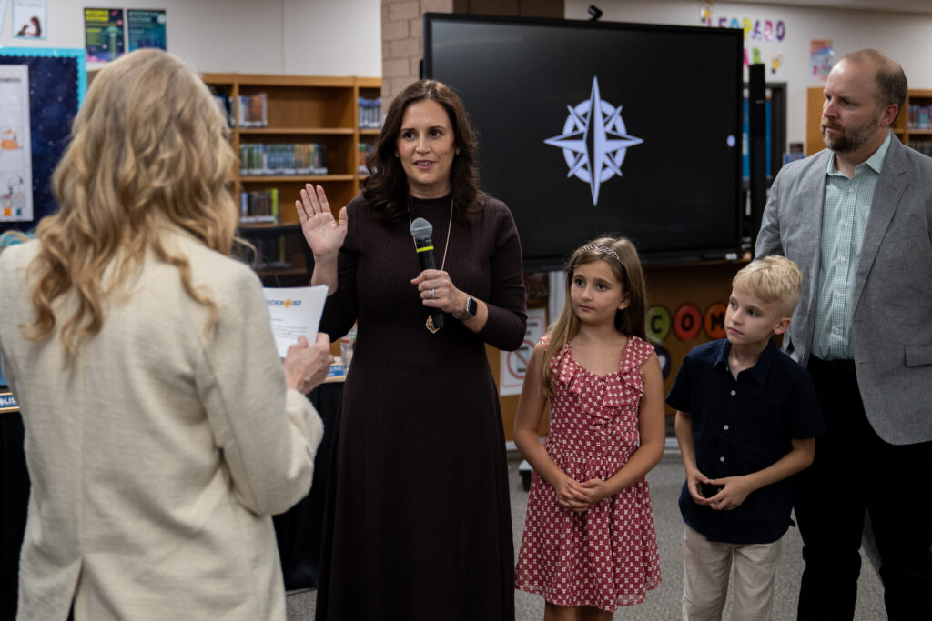 photo of swearing in of new board member with family beside her